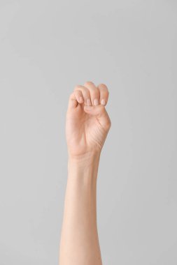 Gri arka planda E harfi görünüyor. İşaret dili alfabesi