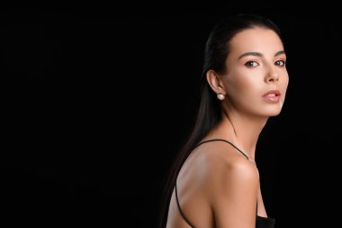 Koyu arkaplanda güzel göz farı olan genç bir kadın.