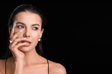 Koyu arkaplanda güzel göz farı olan genç bir kadın.