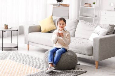 Küçük kız evde lezzetli çikolatalı süt içiyor.