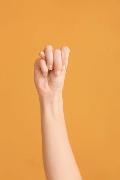 Hand showing letter M on color background. Sign language alphabet