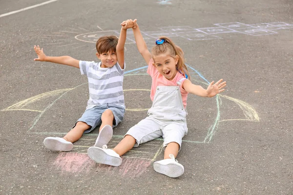 Kleine Kinder Sitzen Auf Kreidezeichnung Einer Rakete Freien — Stockfoto