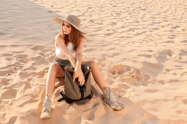 Çölde sırt çantalı güzel bir kadın.