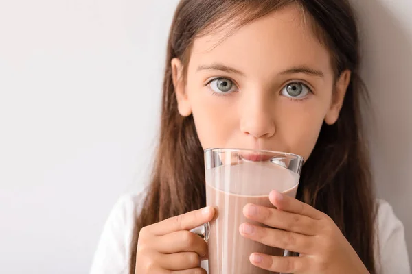 Little Girl Drinking Tasty Chocolate Milk Light Background — Stock Photo, Image