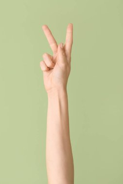 Renk arkaplanında K harfi görünüyor. İşaret dili alfabesi