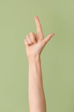 Renk arkaplanında L harfi gösteriliyor. İşaret dili alfabesi