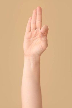 Renk arkaplanında F harfi görünüyor. İşaret dili alfabesi