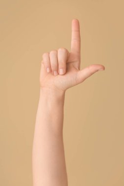 Renk arkaplanında L harfi gösteriliyor. İşaret dili alfabesi