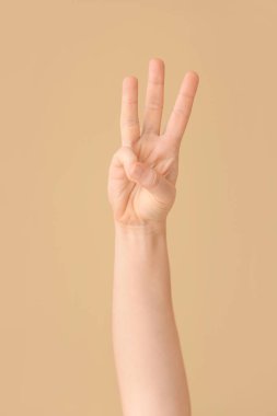 Renk arkaplanında W harfi görünüyor. İşaret dili alfabesi