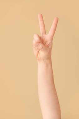 Renk arkaplanında V harfi görünüyor. İşaret dili alfabesi