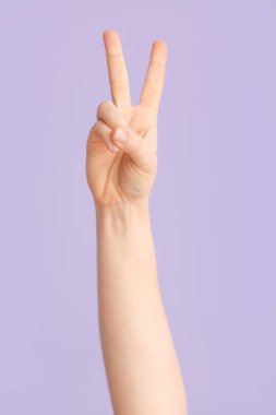 Renk arkaplanında V harfi görünüyor. İşaret dili alfabesi