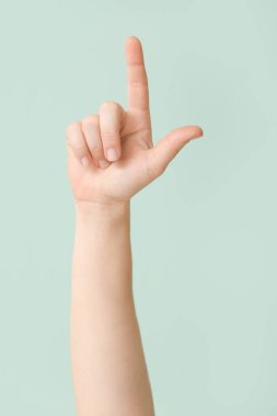 Renk arkaplanında L harfi gösteriliyor. İşaret dili alfabesi