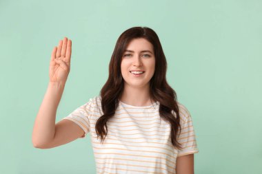 İşaret dilini arka planda kullanan sağır ve dilsiz bir kadın.