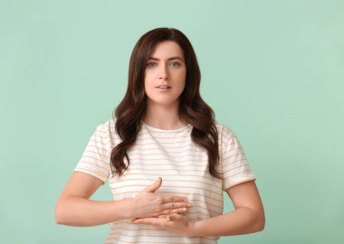 İşaret dilini arka planda kullanan sağır ve dilsiz bir kadın.