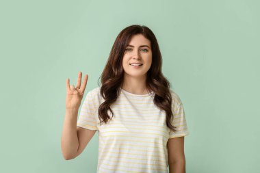 İşaret dilini arka planda kullanan sağır ve dilsiz bir kadın.