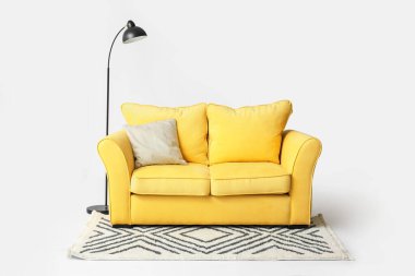 Şık bir kanepe, halı ve lamba.