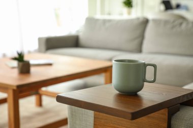 Oturma odasındaki koltukta bir fincan çay.