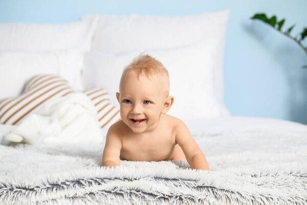 Cute little baby on bed at home