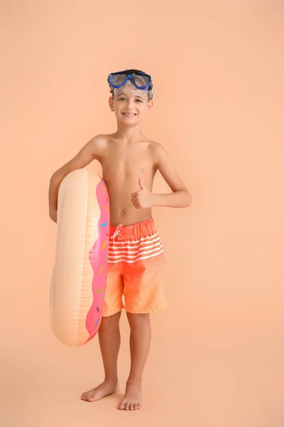 小さな男の子でシュノーケリングマスクとインフレータブルリング上の色の背景 — ストック写真