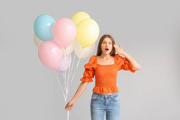 Verrast Jonge Vrouw Met Ballonnen Grijze Achtergrond — Stockfoto