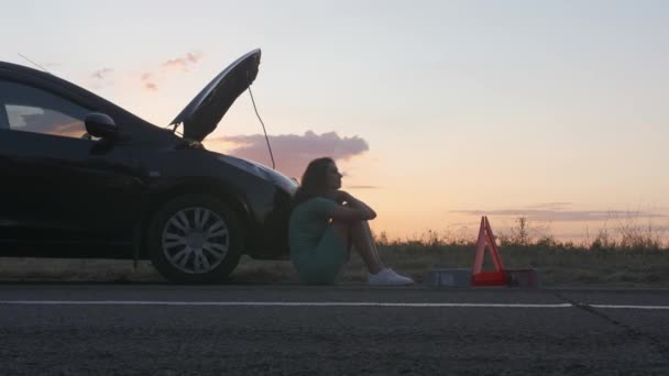 Νεαρή Γυναίκα Κάθεται Κοντά Σπασμένο Αυτοκίνητο Στην Ύπαιθρο — Αρχείο Βίντεο