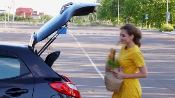 Młoda Kobieta Wkłada Torbę Spożywczą Bagażnika Samochodu — Wideo stockowe