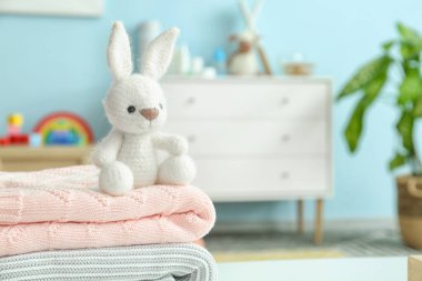 Çocuk odasında masasında giysileri olan sevimli bir oyuncak.