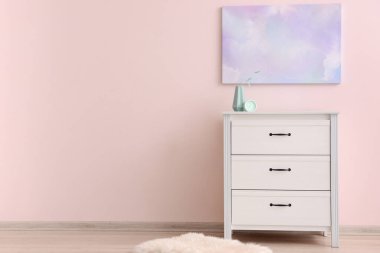 Renkli duvarın yanında dekor olan modern çekmeceler.