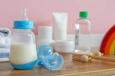 Bebek için bir şişe süt ve emzik.