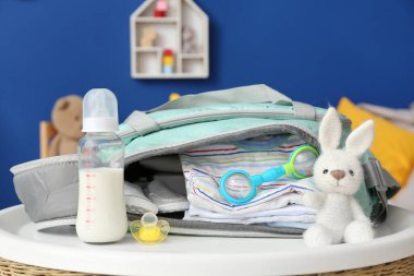 Odadaki aksesuarlı bebek için bir şişe süt.