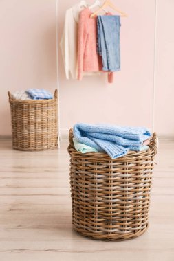 Soyunma odasında üzerinde giysiler olan sepet.