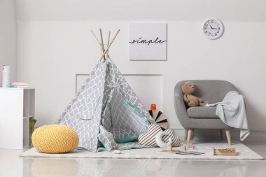 Çağdaş çocuk odasının içinde oyun çadırı ve oyuncaklar var.