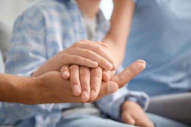 Aile evde el ele tutuşuyor, yakın çekim.