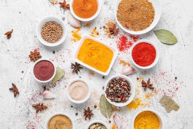 Beyaz arka planda farklı aromatik baharatlar bulunan kaseler