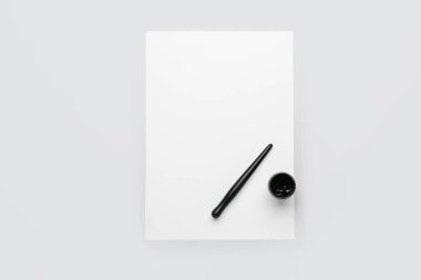 Kağıt, kalem ve mürekkep beyaz arkaplanda.