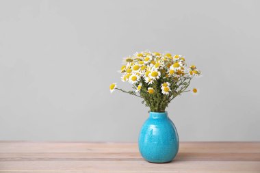 Vazoda bir buket taze papatya çiçeği ve gri arka plan.