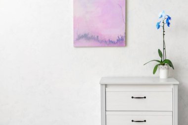 Çekmecelerin modern sandığı, odanın ışık duvarının yanında.