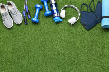 Spor ekipmanları, arka planda bir şişe su ve kulaklık.