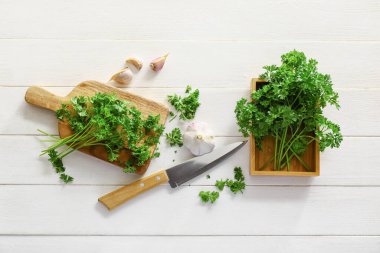 Taze maydanozlu kompozisyon ve beyaz arka planda sarımsak.