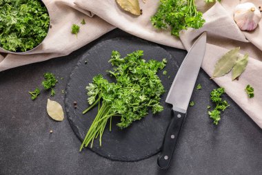 Siyah arka planda taze maydanoz ve bıçak.