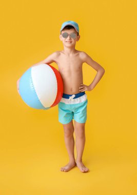 Arka planda plaj topu olan küçük çocuk.