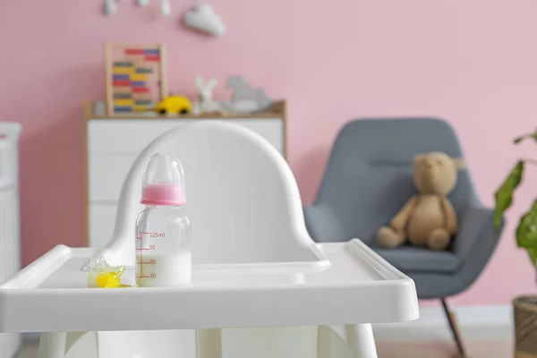 房间里高椅子上的婴儿用的牛奶瓶 — 图库照片