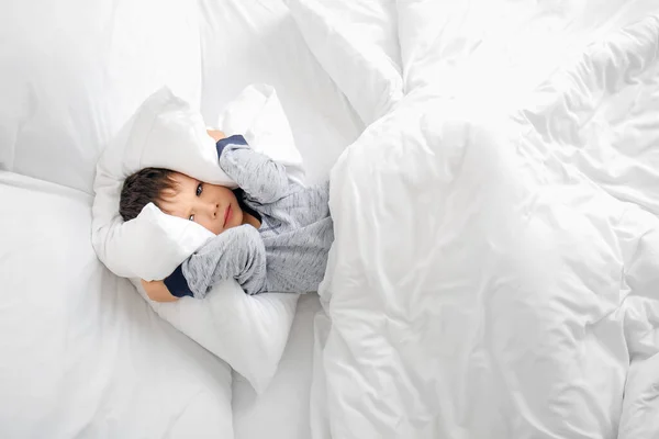Little boy suffering from sleep disorder in bedroom
