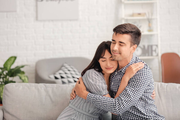 Happy couple hugging after quarrel at home