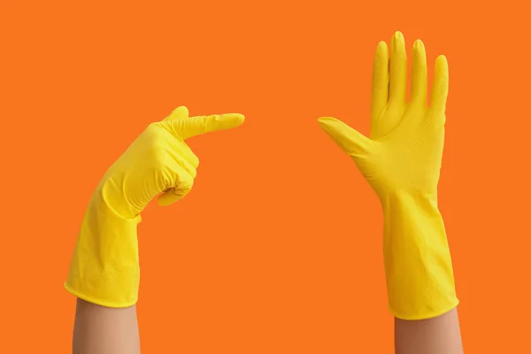 Gesturing hands in rubber gloves on color background