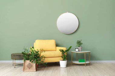 Renkli duvarın yanında şık koltuğu, aynası ve çiçekleri olan bir oda.