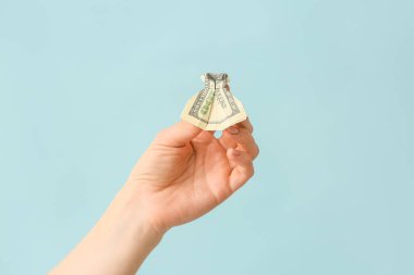 Origami elbisesi dolar banknotundan yapılmış kadın eli.