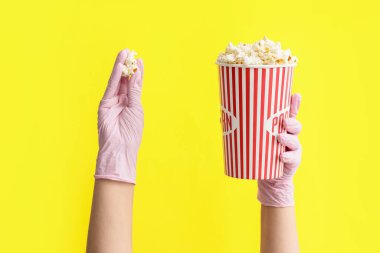 Eller koruyucu eldivenlerde ve arka planda patlamış mısırla