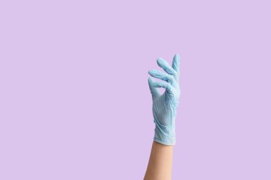 Renk arkaplanı üzerinde koruyucu eldivenle el hareketi