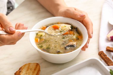 Masada lezzetli pirinç çorbası içen bir kadın.